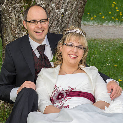 Brautpaar lehnt am Baum