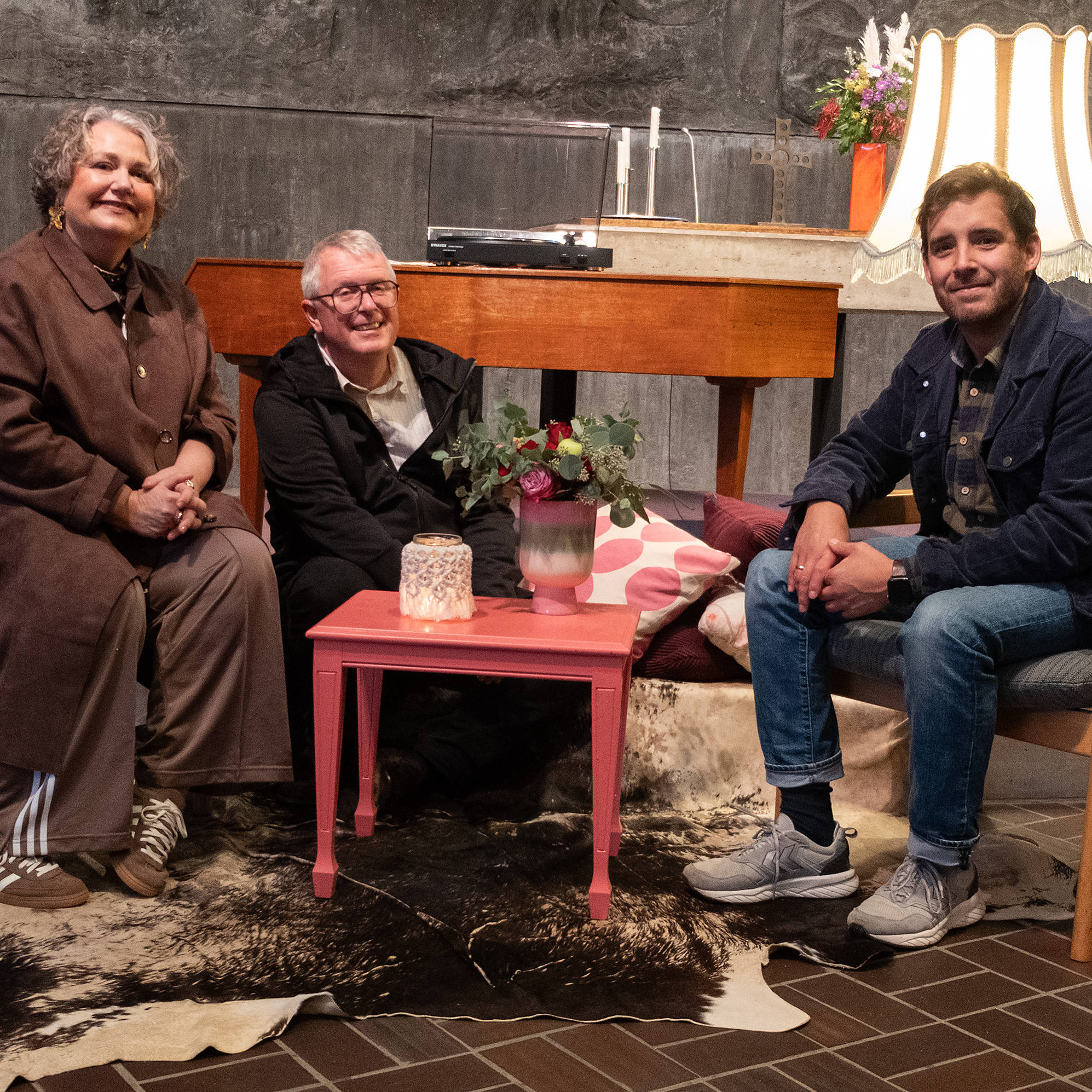 Gönna Müller, Martin Müller und Pastor Mario Rusch-Langkafel auf Sesseln in der Kirche des Eivind-Berggraf-Zentrums