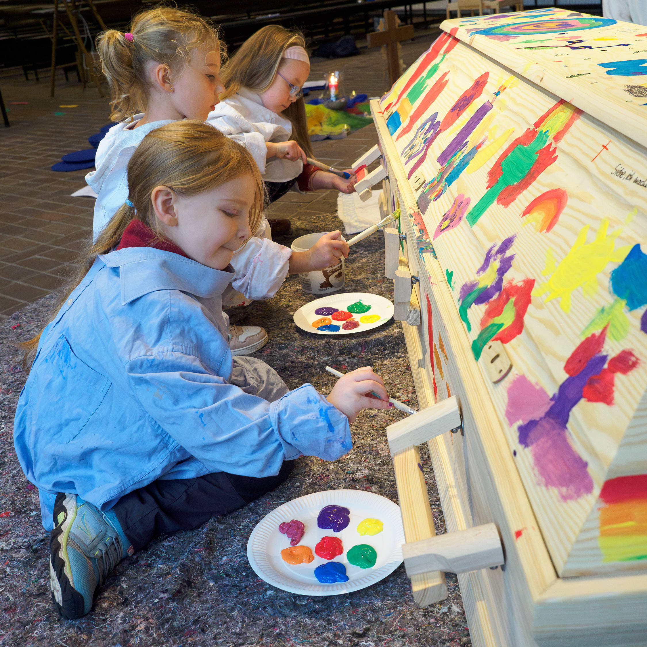 Kinder bemalen einen Sarg