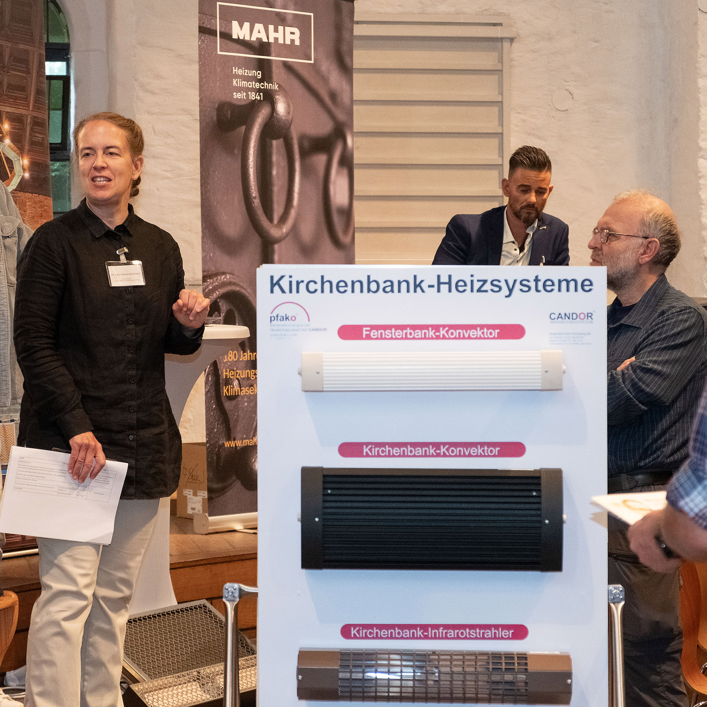 Julia-Maria Hermann vor der Werbetafel für Kirchenbankheizungen