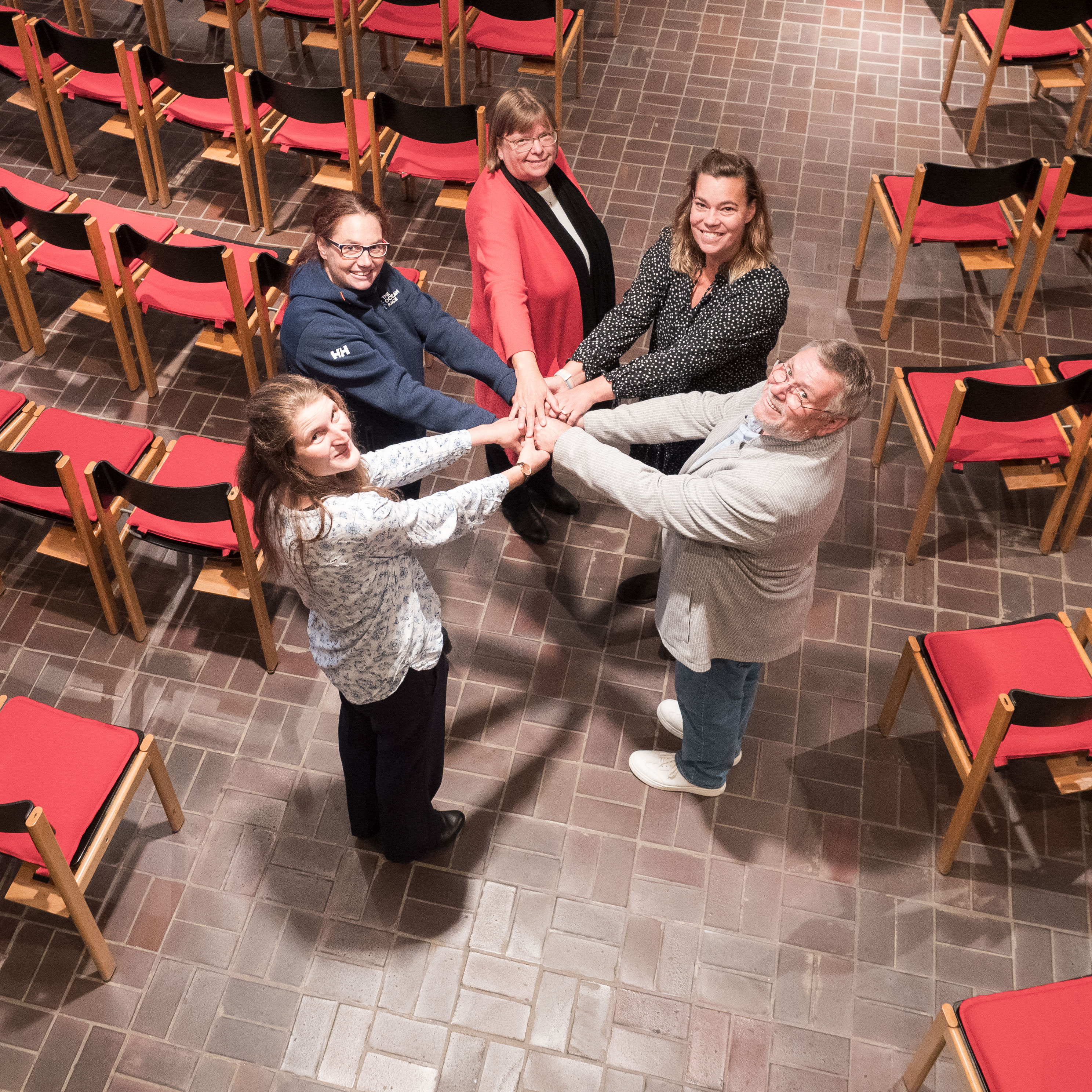 Team zur Fusuion der Kompassgemeinde hält sich an den Händen.